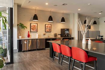 A modern kitchen with red chairs and a wooden floor at Regatta Sloans Lake Apartments, Denver, CO, 80204